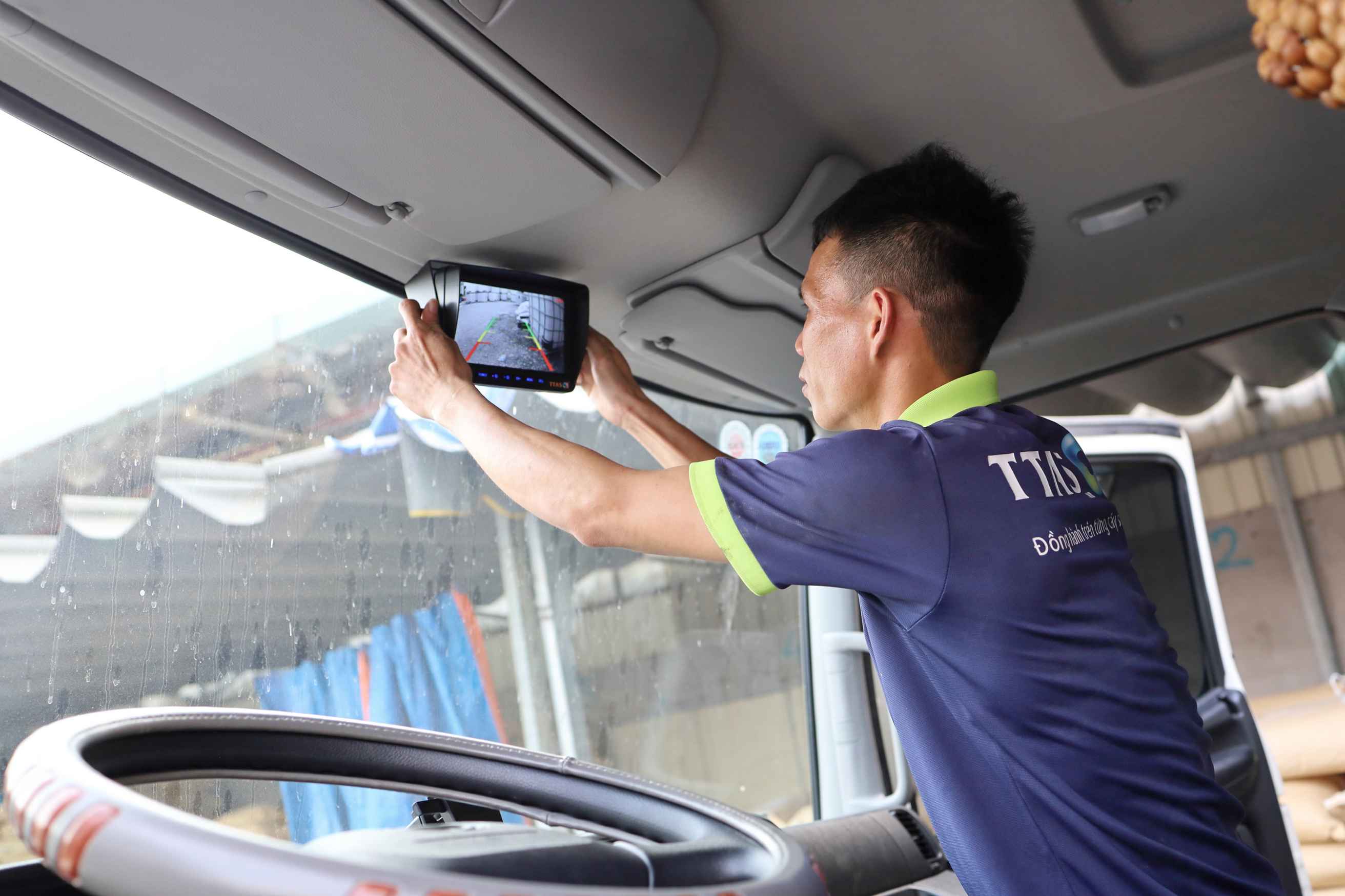Kỹ thuật viên lắp đặt màn hình camera lùi trên cabin xe tải